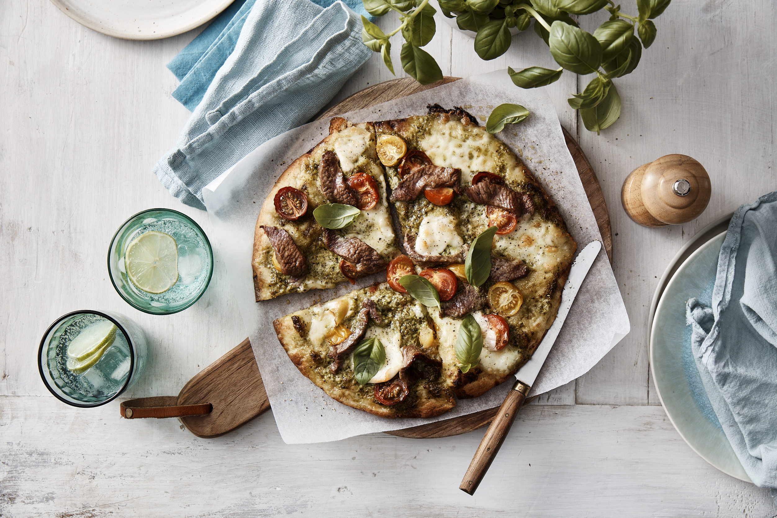 Pesto Lamb Caprese Pizza overhead shot, cooked and cut into quarters